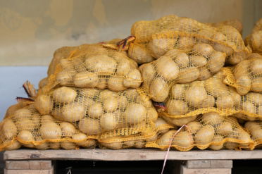 a pile of potatoes sitting on top of a wooden pallet