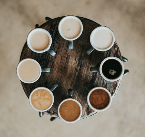 flat lay photography of eight coffee latte in mugs on round table