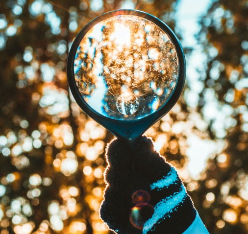 person holding black magnifying glass