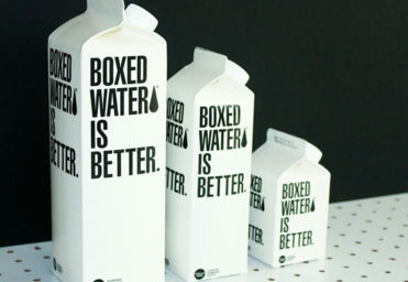 Three different sized Boxed Water cartons on a black and white background