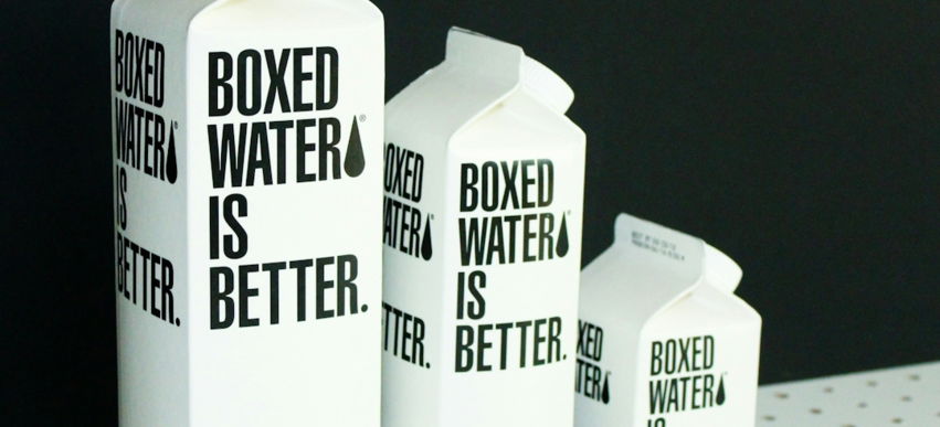 Three different sized Boxed Water cartons on a black and white background